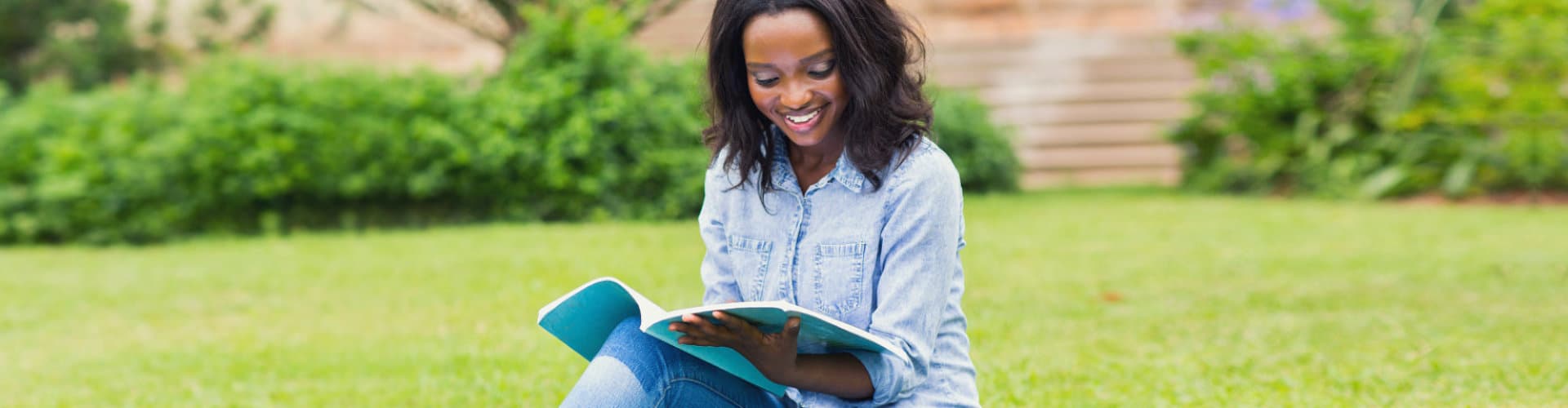 young woman studying on a grassfield